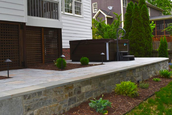 Patio in backyard with retaining wall.